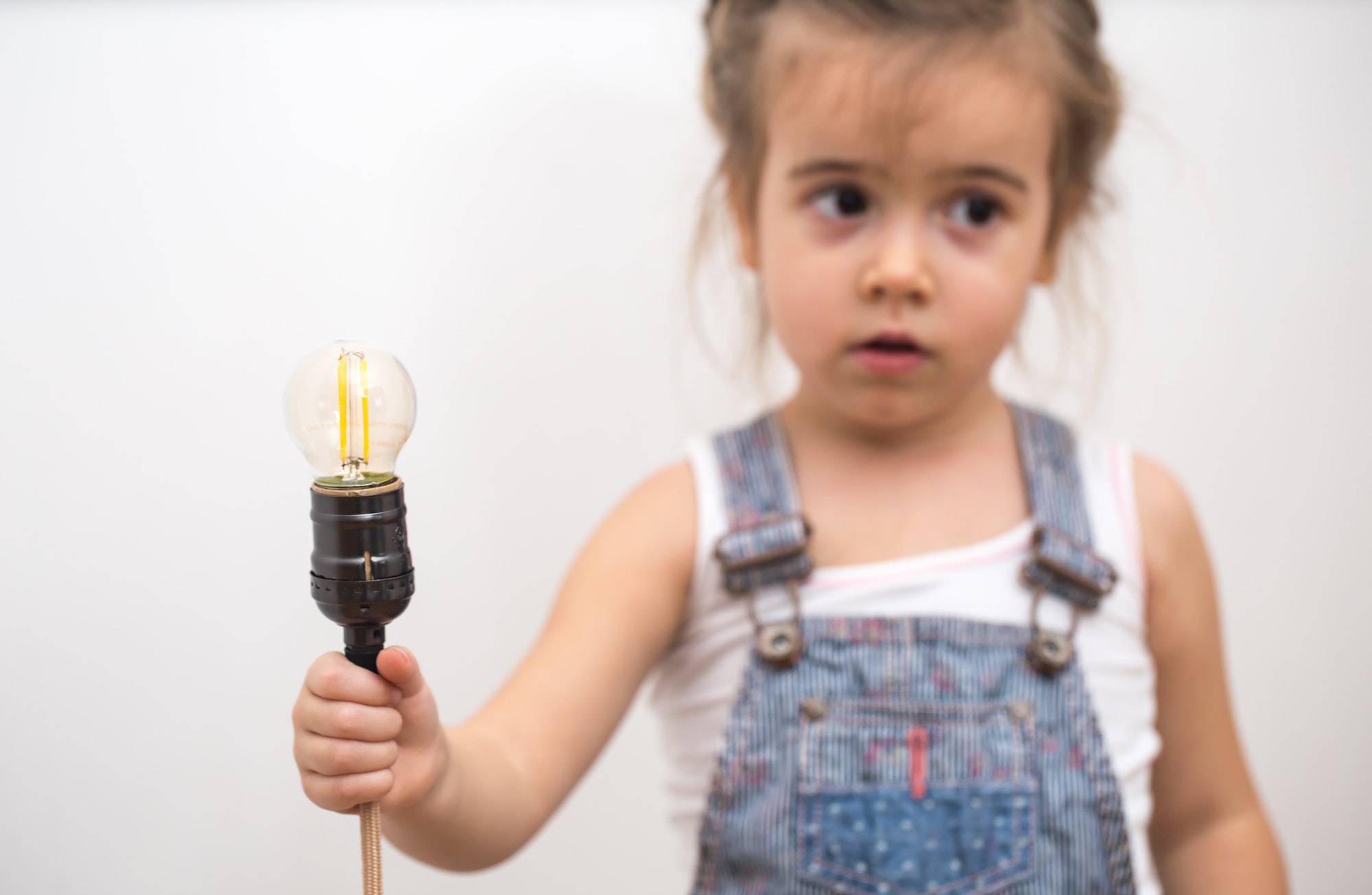 little cute girl with light bulb in hand
